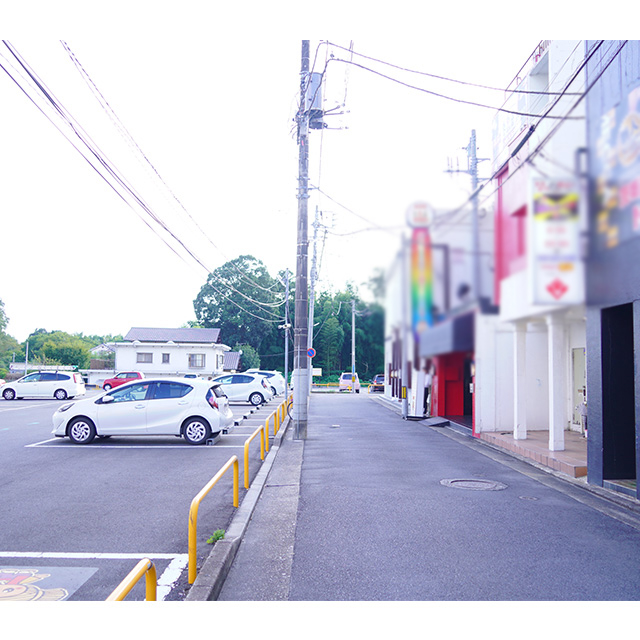 この道の右側に見える赤い建物が目印です。