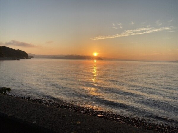 朝焼けの光の中に立つ影は